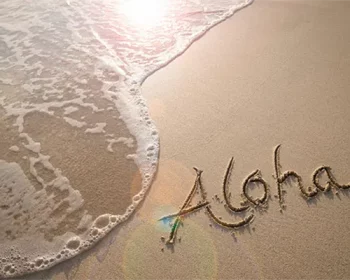 The word "Aloha" written in the sand at a beach.