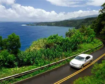 White car driving on a highway in Maui.
