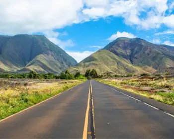 Open road heading towards the mountains in Maui.