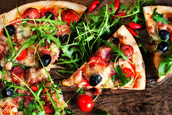 Homemade pizza on a wooden flat board.