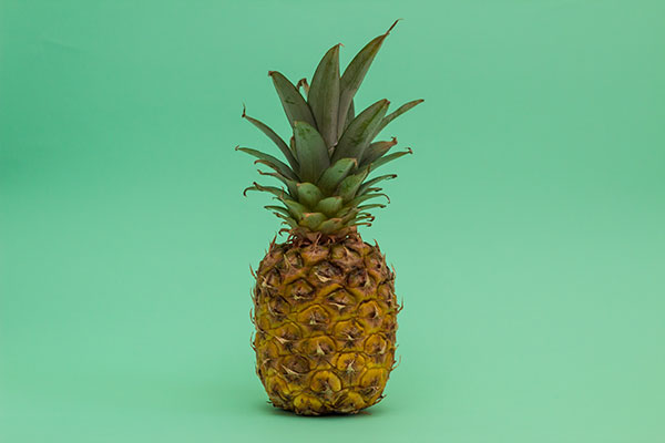 Pineapple posed with a light green background.