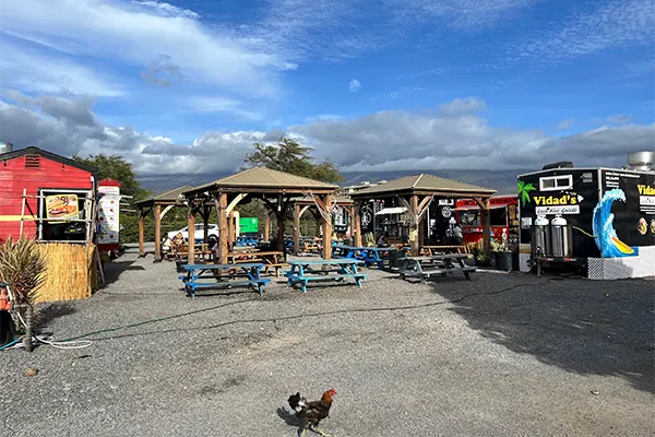 Collection of food trucks in Kihei with benches. 