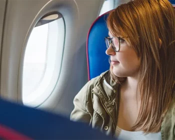 Woman looking out a window on an airplane.