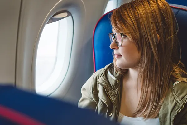 Woman looking out a window on an airplane. 