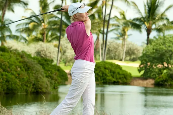 Golfer in Maui swinging a golf club. 