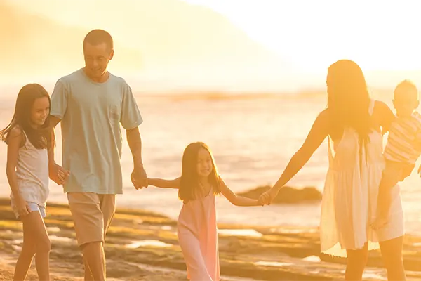 Family holding hands on the beach in Maui