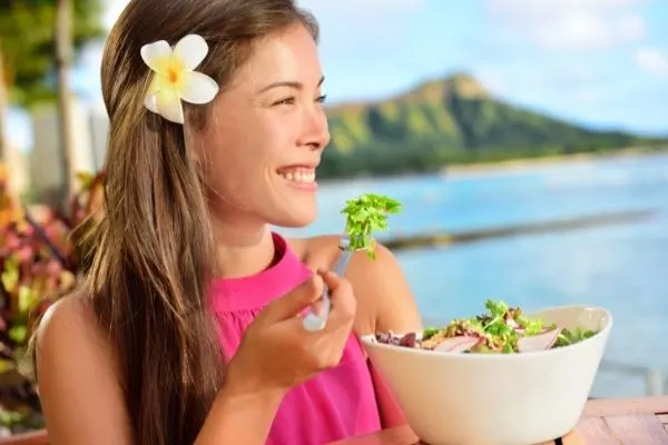 Woman eating salad at a restaurant in Hawaii