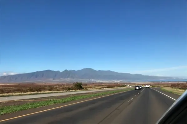 Highway in Maui, mountains in the distance. 