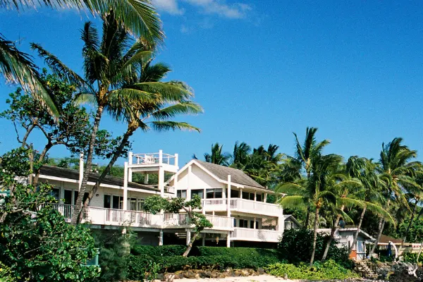 Airbnb in Kihei Maui surrounded by palms and above a beach.