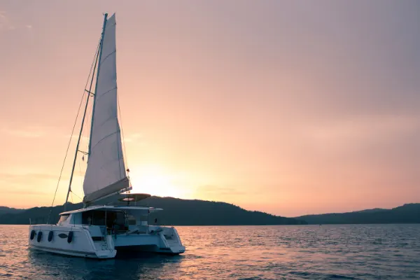 Small yacht in the ocean at sunset. 