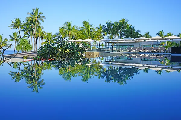 A picture of a resort with cabana and a pool.