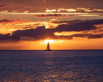 Scenic sunset viewed from Lahaina harbor, Maui, Hawaii. A silhouette of sail boat against setting sun
