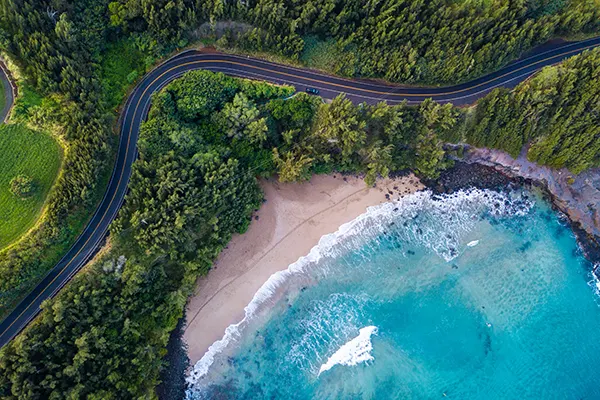 Aerial view of the sandy beach and curved asphalt road on the west coast of Maui. Hawaii