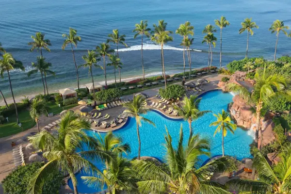 Aerial view of resort pool with ocean in the background.