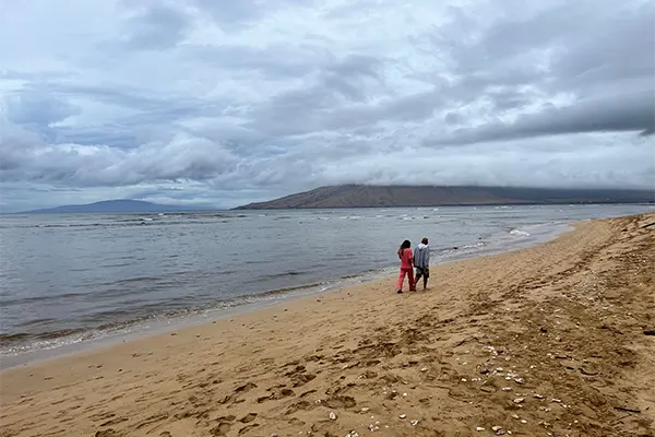 Couple walking along Lipoa Street Beach. 