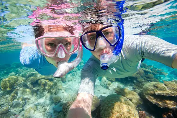 Man and woman snorkeling underwater. 