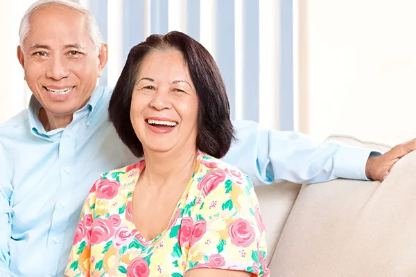 Two seniors, a man and woman, smiling at the camera. 