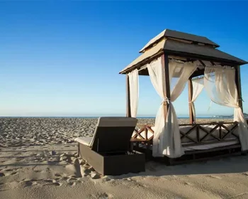 A cabana on the beach looking out at a blue sky.