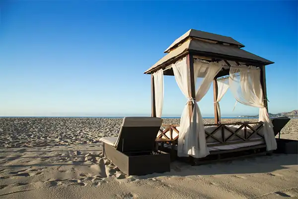 A cabana on the beach looking out at a blue sky. 