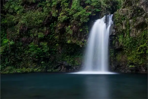 A waterfall in Maui pouring into a pool.