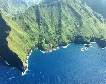 Aerial shot of Molokai, green mountains and blue ocean.
