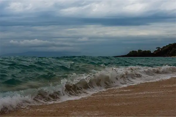 Rolling waves on the shore in Maui on a cloudy day. 