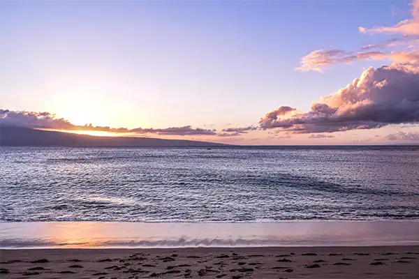 Kaanapali Beach at sunset, a gentle tide laps the beach. 