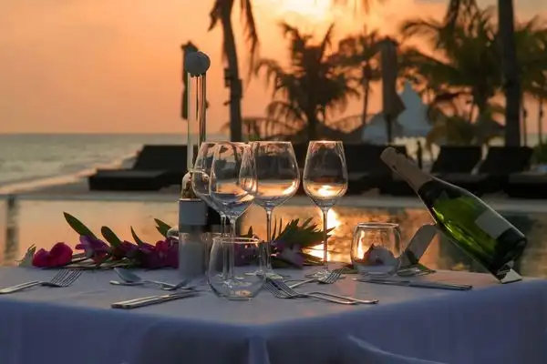 Two wine glasses on a table at sunset in Maui.