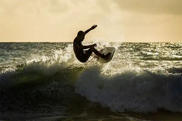 Man catching air on a wave in Maui at sunset.  