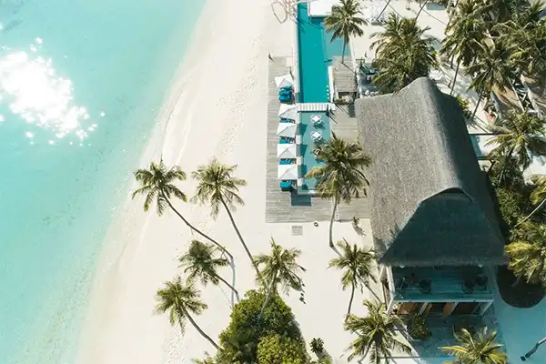 Looking down at a timeshare on the beach, with palm trees. 