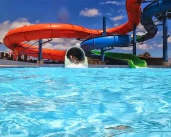 Waterslides at a resort snaking into a pool.