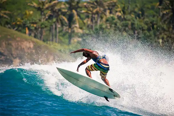 Man surfing, catching some air off a wave. 