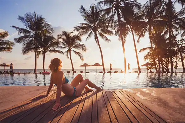 Woman relaxing by the pool in Maui at sunset.