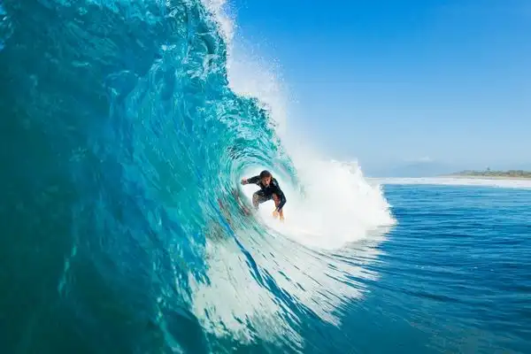 Man surfing a tubular wave in the Maui ocean. 