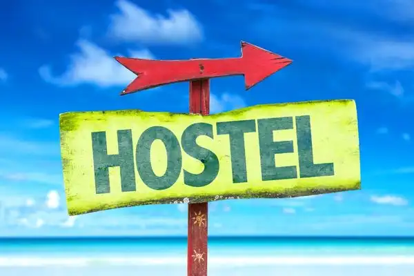A sign on a beach that reads "Hostel."