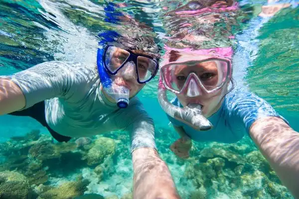 Two people underwater snorkeling.