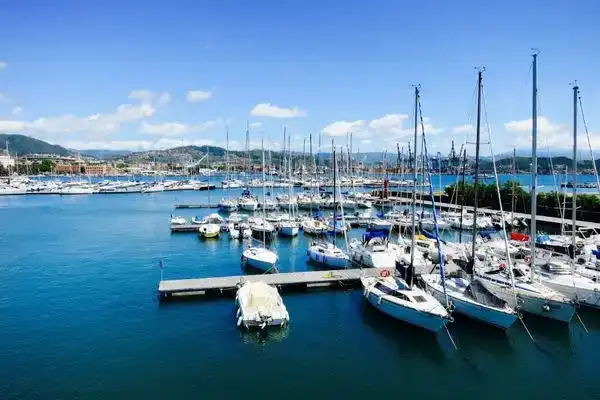 A view of Maalaea Harbor on a sunny day, calm waters, and yachts bobbing.